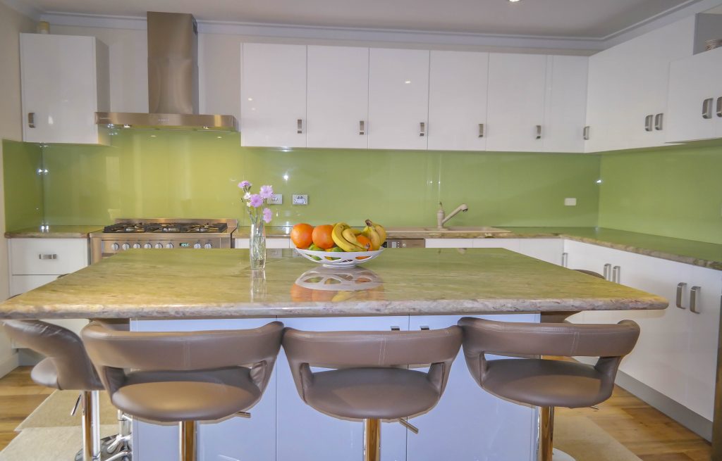 Modern kitchen with green painted glass splashbacks